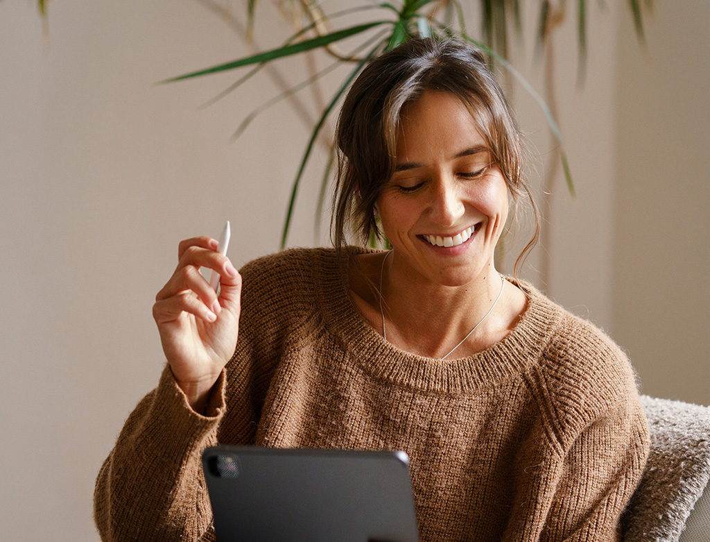 Mujer utilizando un dispositivo para completar el onboarding digital de su empresa