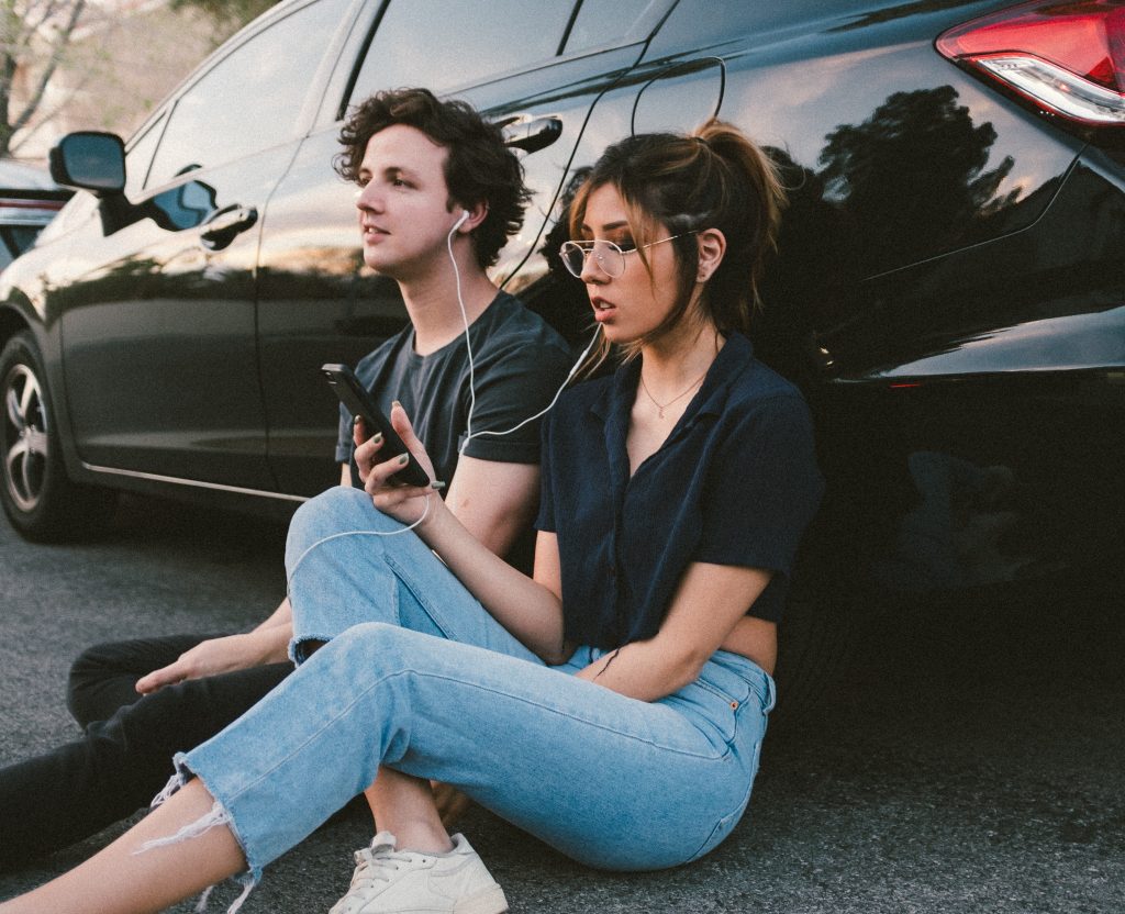 dos chico y chica escuchando música con un teléfono